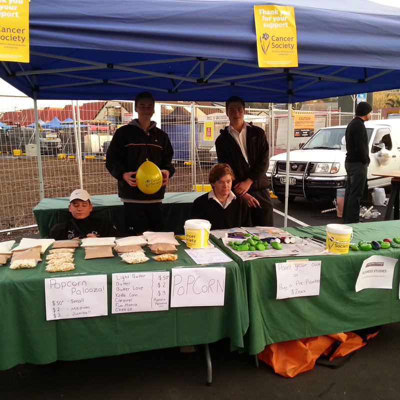 A busker plays guitar under a gazebo.