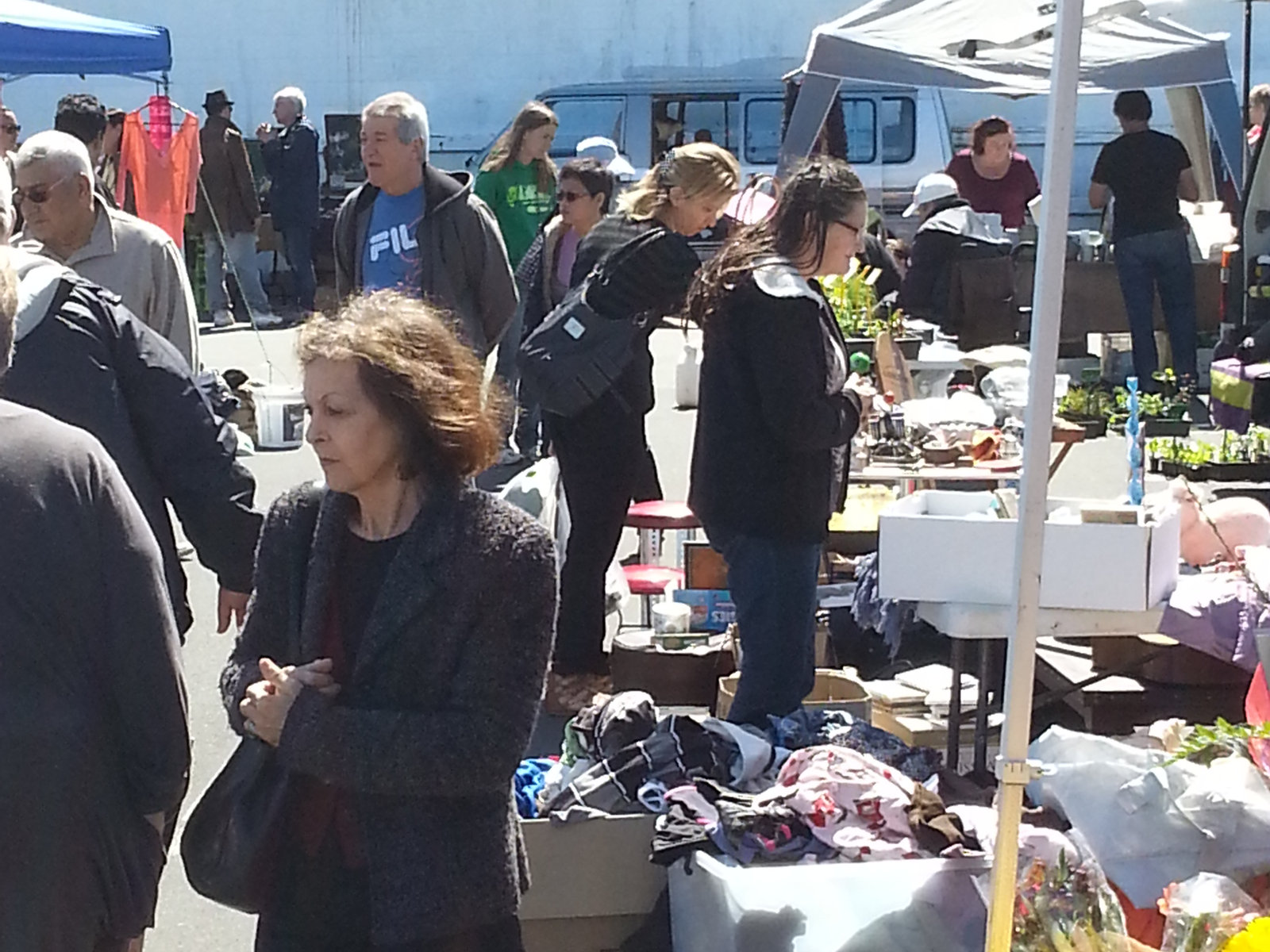 A busker plays an acoustic guitar in the market carpark.